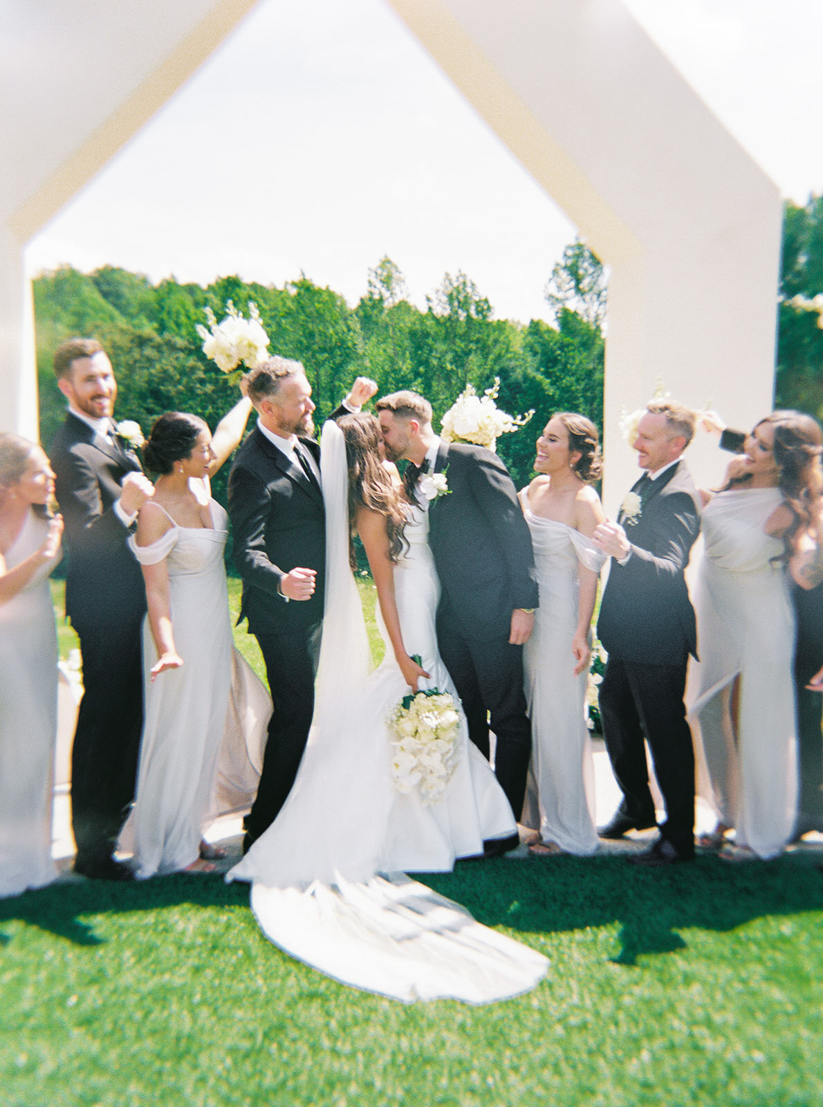 Bridal party portraits under a modern wedding arch outdoors in North Carolina.