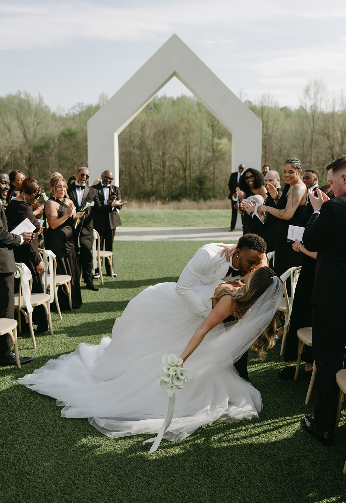 Groom dipping his bride for a kiss as they walk back down the aisle.